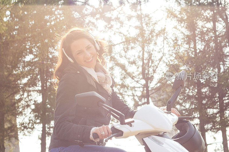年轻女子坐在外面的摩托车上