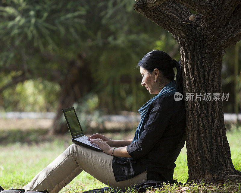 成年女性在大自然中使用笔记本电脑