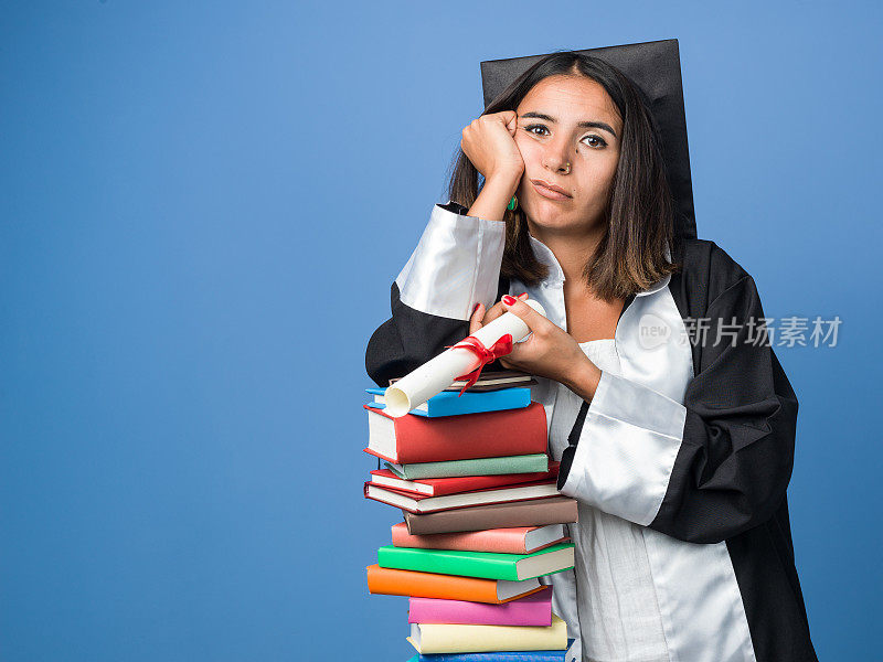 凝视着穿着毕业礼服拿着毕业证书的漂亮女人