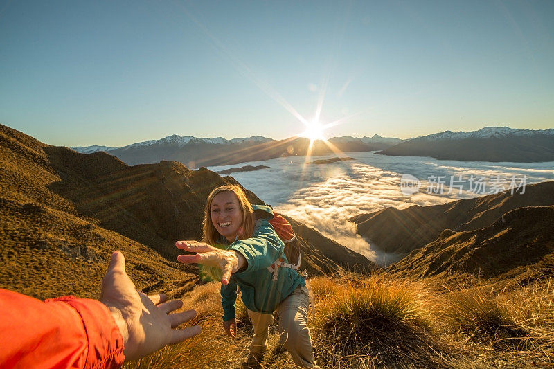 徒步旅行的妇女在山顶得到帮助