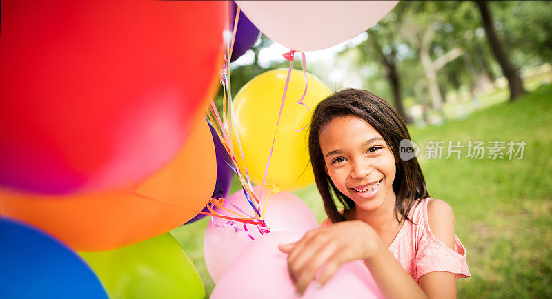 小女孩拿着一堆气球的特写镜头。