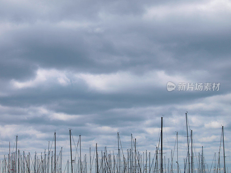 帆船的桅杆顶着暴风雨的天空