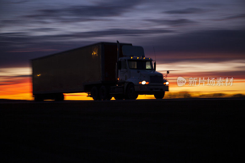 日落时分高速公路上的拖拉机拖车。