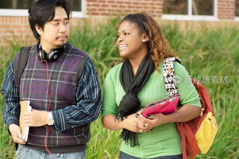 教育:不同的大学生情侣步行去上课。