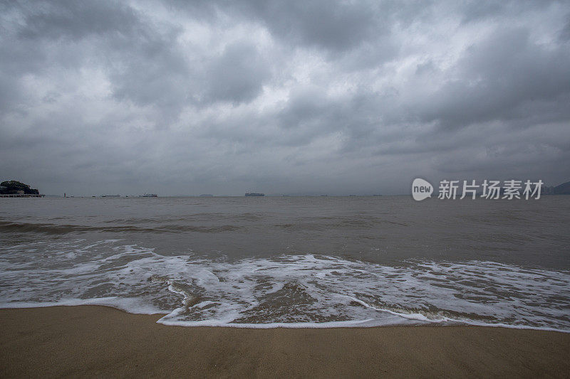 阴天下海浪在海滩上冲浪