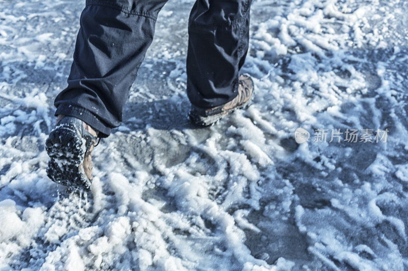 男人的冬季步行靴溅过城市人行道的泥泞