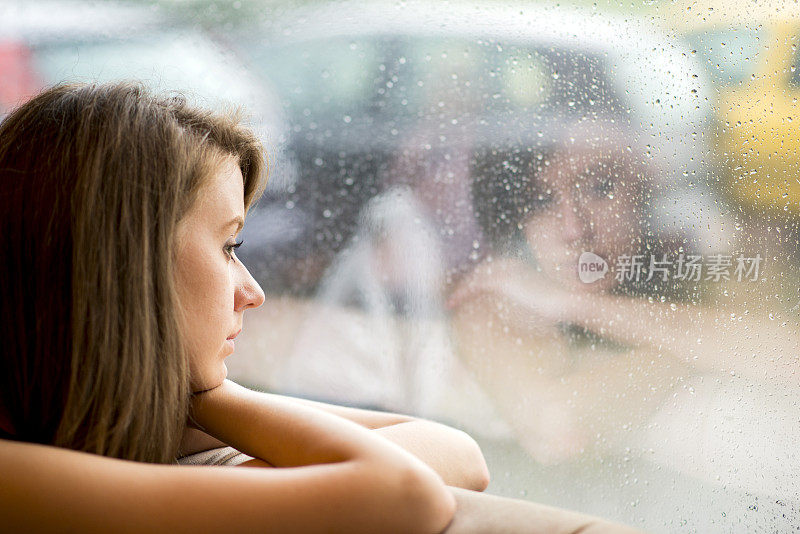 一个下雨天透过窗户看的女人