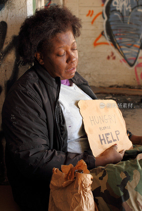 无家可归的女人独自拿着标牌