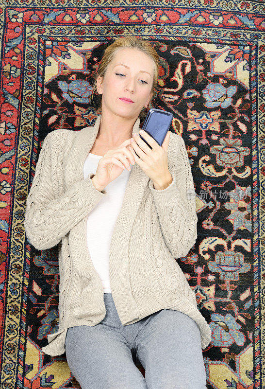 手机躺在地毯上的女人