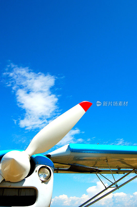 近距离的飞机螺旋桨在明亮的蓝色天空