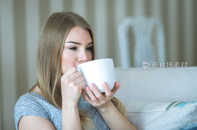 年轻女子在家里用一杯饮料