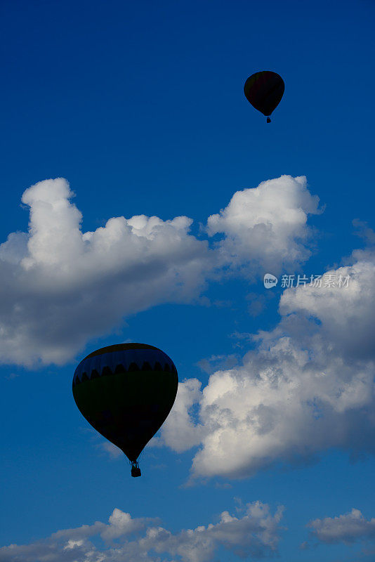 多云天空中热气球的剪影