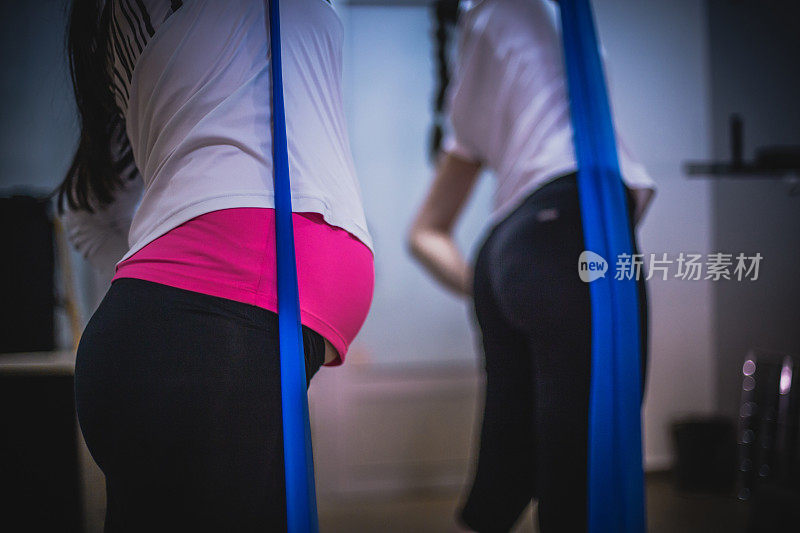 孕妇在健身馆与健身教练一起锻炼