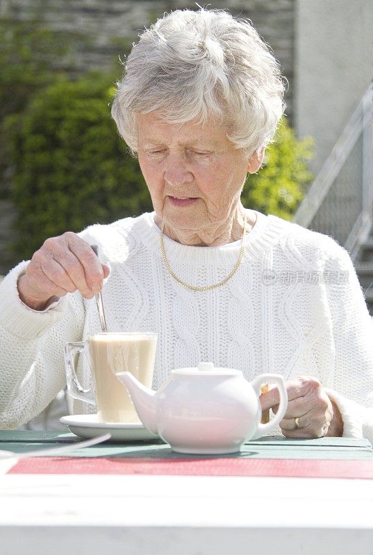 老妇人在喝咖啡