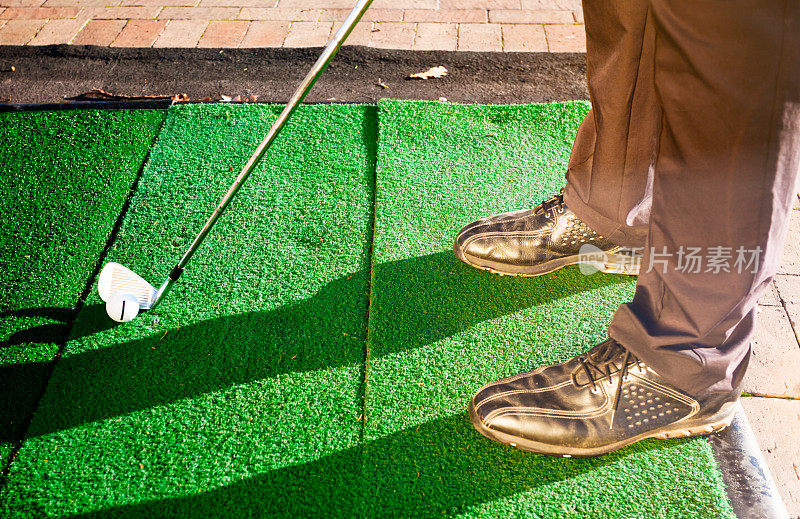 高尔夫球手在人造草皮练习场练习的脚