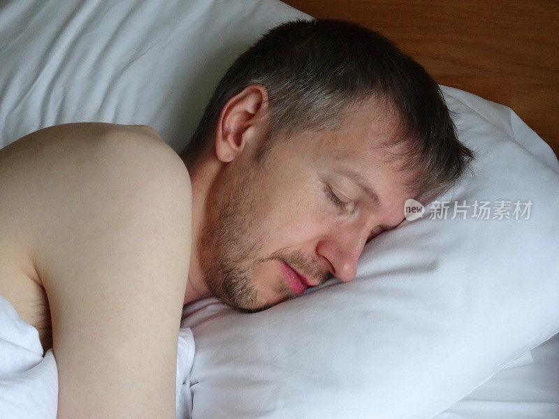 裸体男人睡在床上，呼呼大睡，胡子拉碴
