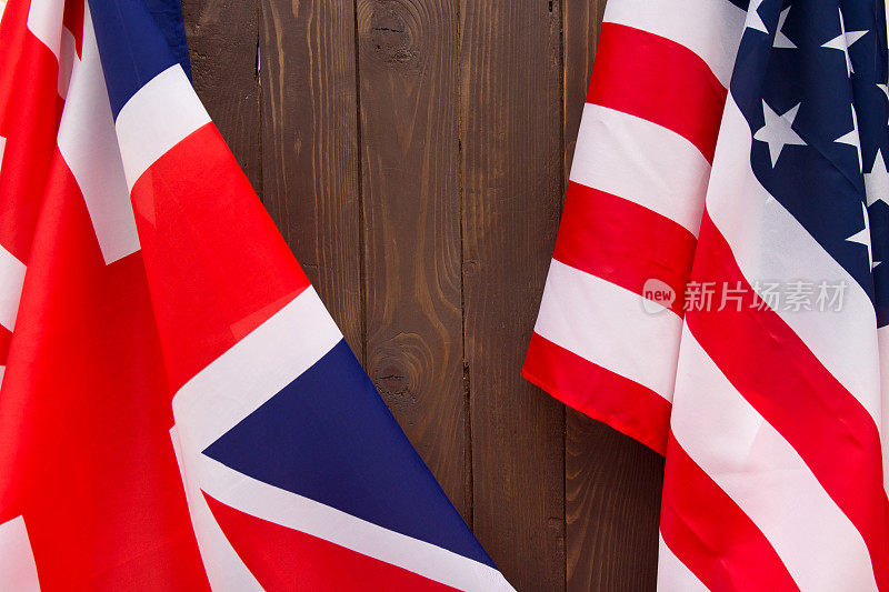 木制棕色背景的英国国旗和美国国旗。