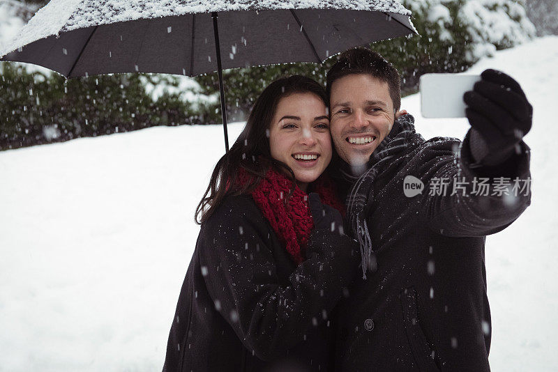情侣在下雪时用手机自拍