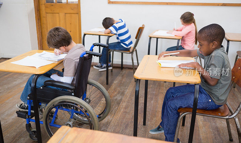 残疾学生在教室书桌上写字