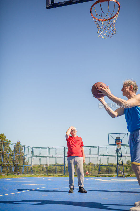 一群老年人在户外进行体育活动，打篮球