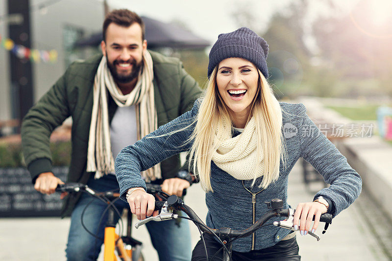年轻夫妇骑着自行车，在城市里玩得很开心