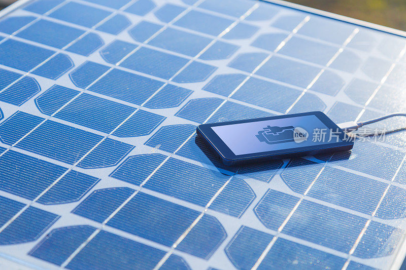 用太阳能板给手机充电。