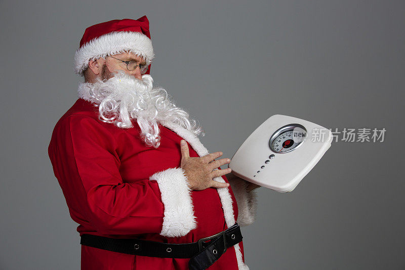 圣诞老人看着体重秤