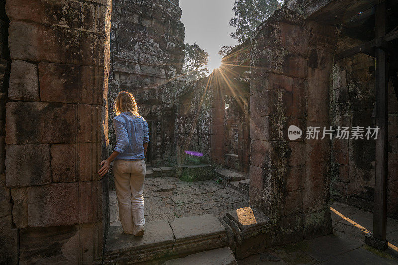 女游客漫游在古老的寺庙日落享受发现和旅游在亚洲，柬埔寨吴哥窟