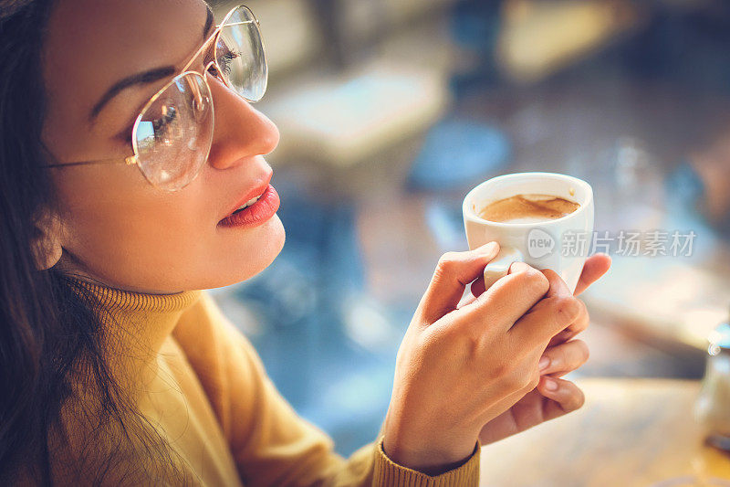 在家喝茶或喝咖啡的女人。窗外景色