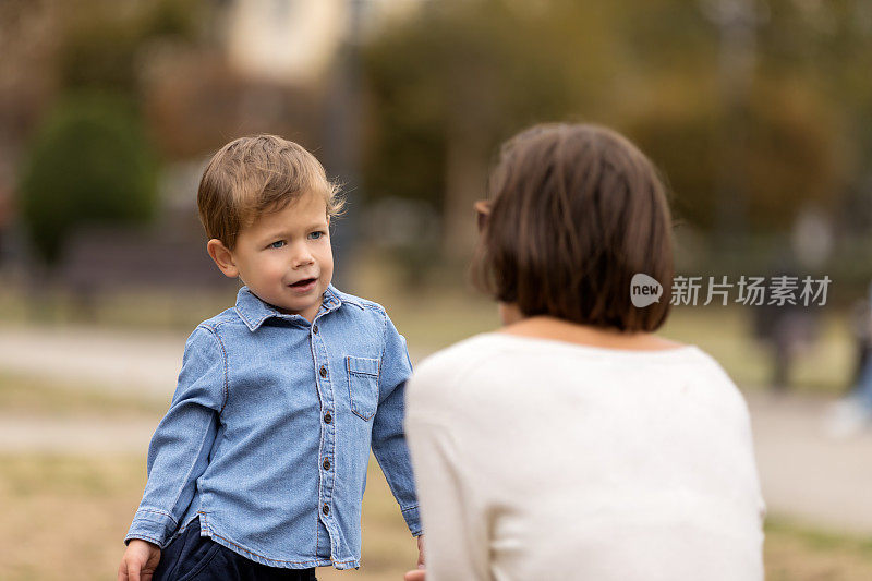 可爱的小男孩在户外向妈妈抱怨。