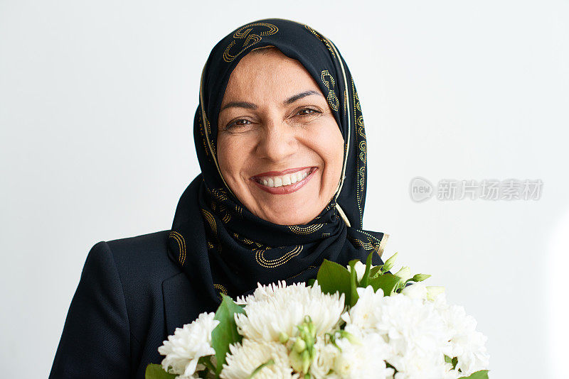 兴高采烈的穆斯林妇女拿着花束