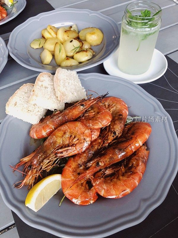地中海虾、大虾、迷迭香、马铃薯和面包