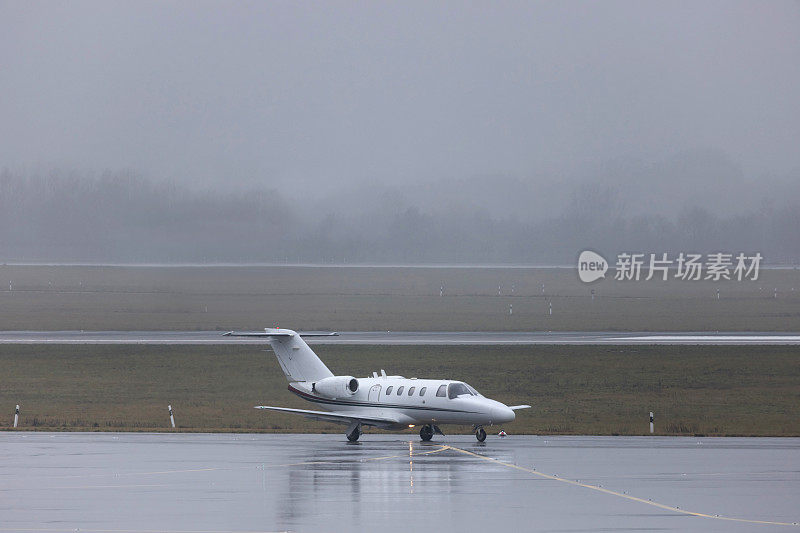 一架私人飞机在下雨的机场上