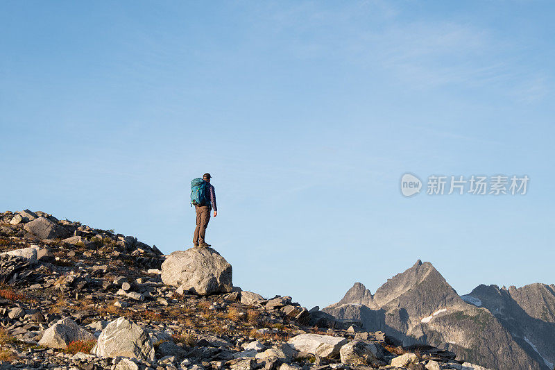 一名男性徒步旅行者望着山脉上方的景色