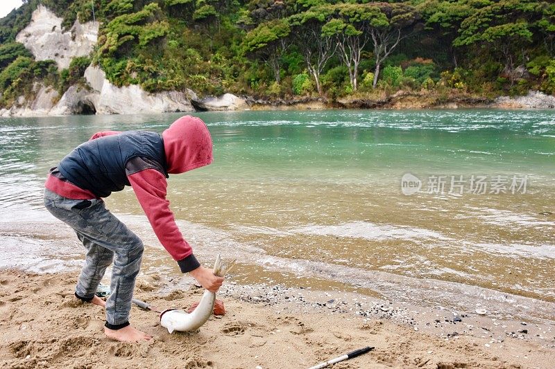 男孩和夏威夷鱼在海岸