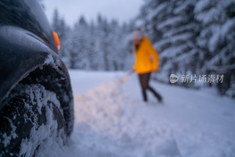 第一场雪后打扫汽车和扫地。紧急照明设备。在恶劣的天气下，汽车会在偏僻的地方抛锚。汽车保险。一个女人在路上。