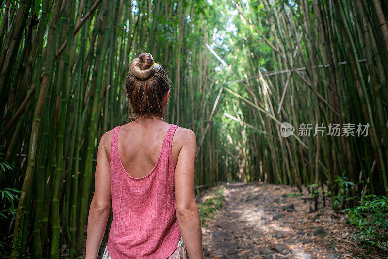 年轻女子在竹林中漫步，探索大自然