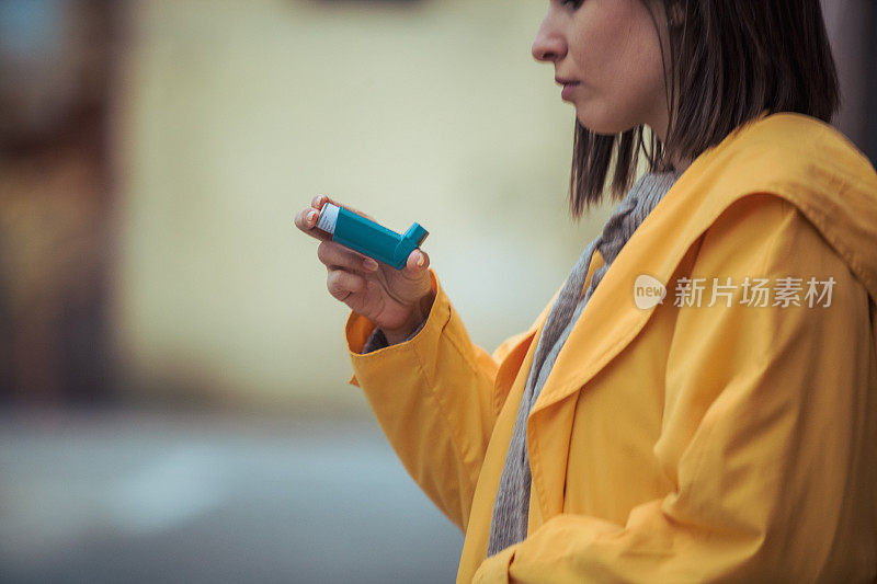 年轻女子使用哮喘吸入器