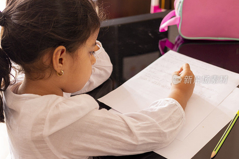 女孩在一张小桌子旁写字