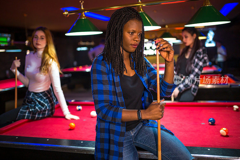 年轻的非洲裔美国妇女在打台球