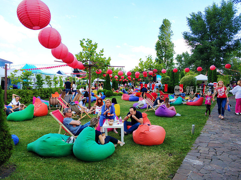 庆祝在一个绿色的公园。夏季野餐。一群人正在公园里休息