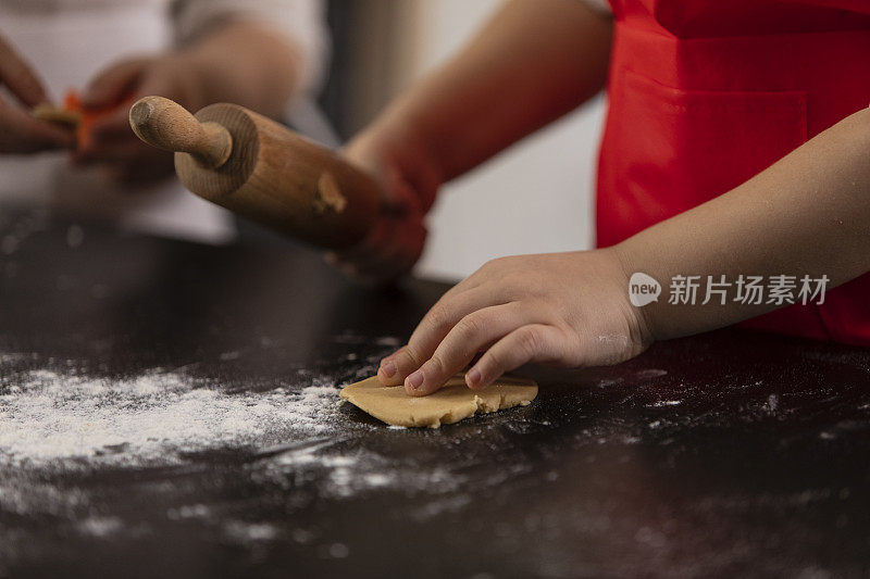 一个面目全的小女孩正在擀姜饼