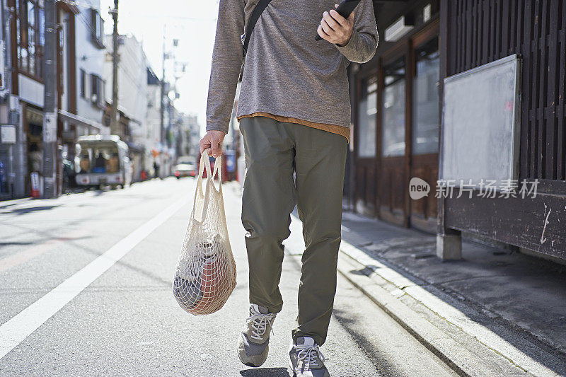 一名日本男子在京都街头使用可重复使用的棉网袋