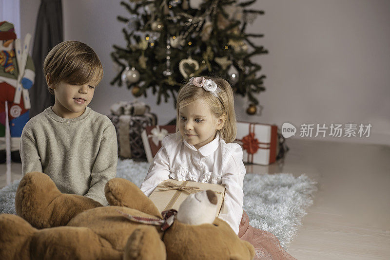 孩子们和圣诞礼物在圣诞树旁，拆礼物，孩子们喜欢在客厅里庆祝圣诞，快乐的圣诞时光