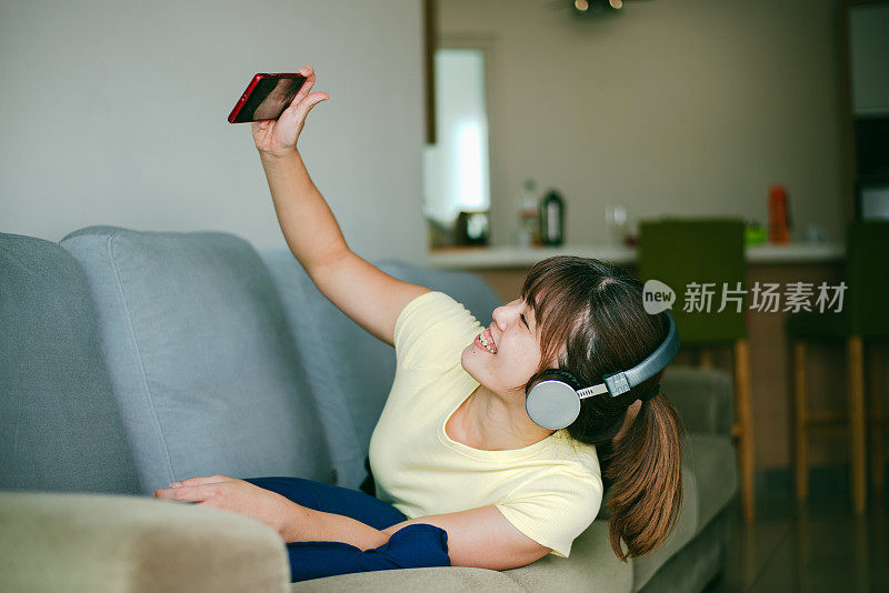美丽的亚洲女人喜欢在家里的数字平板电脑上视频聊天。