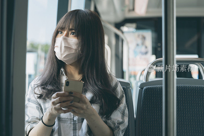 年轻女子在乘坐地铁时使用智能手机