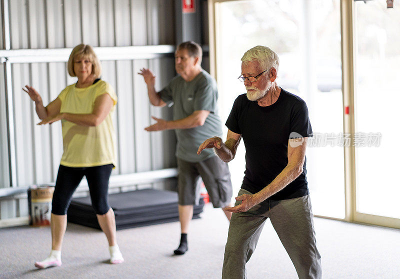 一群老年人在太极班以积极的退休生活方式锻炼。锻炼和健身对老年人身心健康的益处。高级保健和福利概念。
