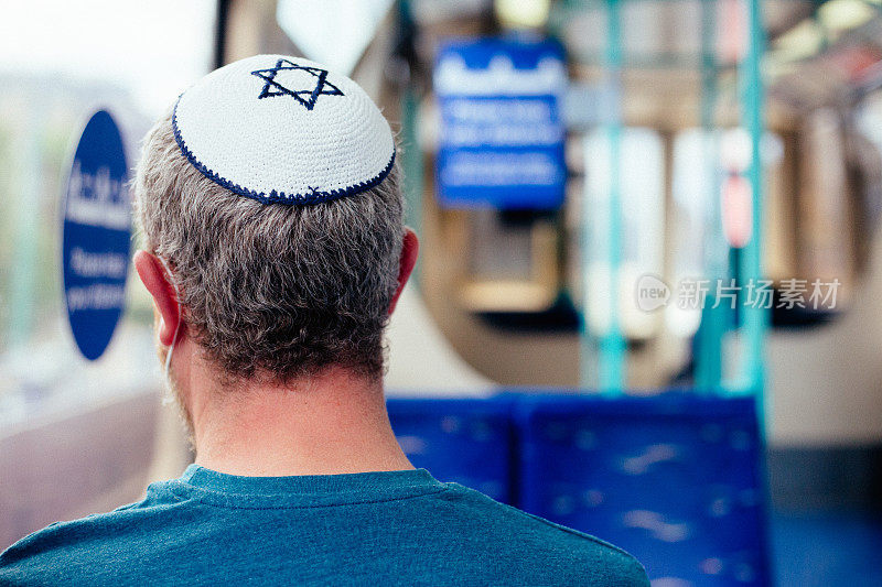 犹太男子戴着便帽在旅客列车上