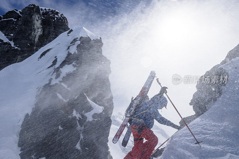 偏远地区的滑雪者攀登积雪的山坡