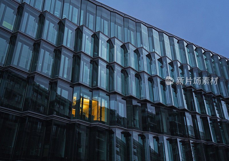 德国柏林，黎明时分，现代建筑中被照亮的窗户的低角度视图